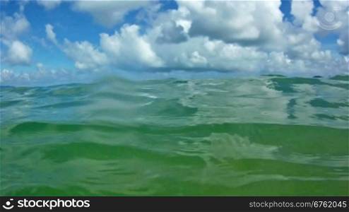 Waves in open sea and blue sky with clouds