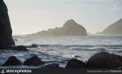 Waves lap on Pfeiffer beach with view of dramatic rocks