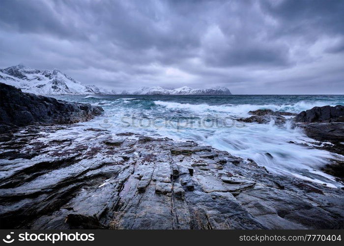 Waves of Norwegian sea crushing at rocky coast in fjord. Vikten, Lofoten islands, Norway. Norwegian Sea waves on rocky coast of Lofoten islands, Norway