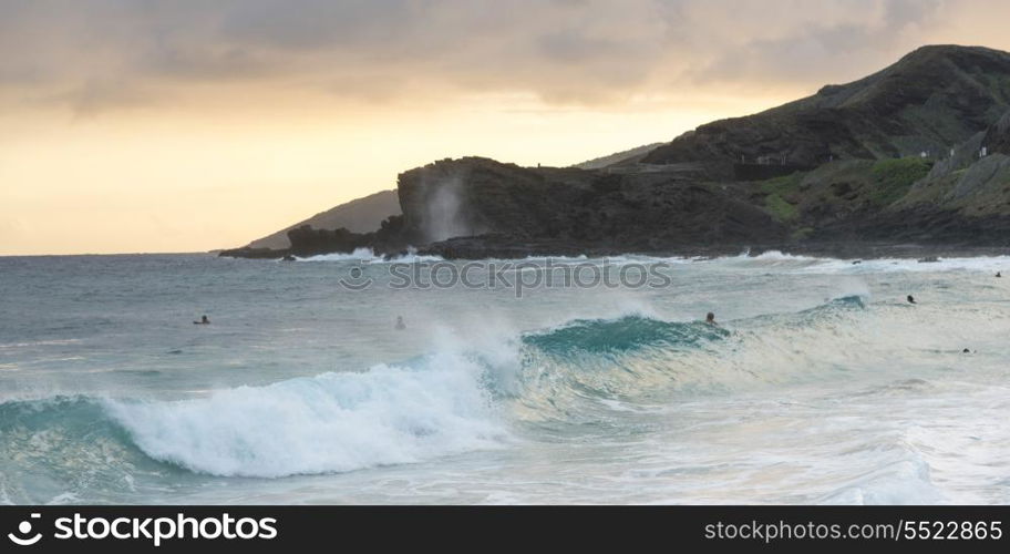 Waves on the beach with surfers at dusk, Sandy Beach, Honolulu, Oahu, Hawaii, USA