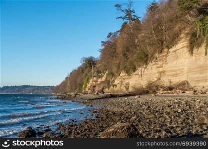 Waves roll onto a rocky shore at Saltwater State Park in Washington State. A high structure enables access to the beach.