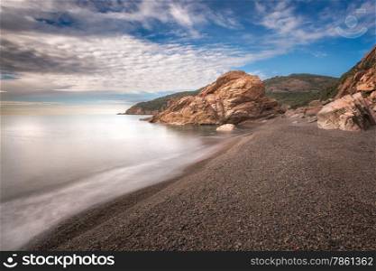 Waves washing onto pebbles at Bussagli beach near Porto in western Corsica