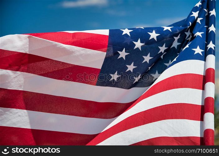 Waving American Flag on blue sky background.