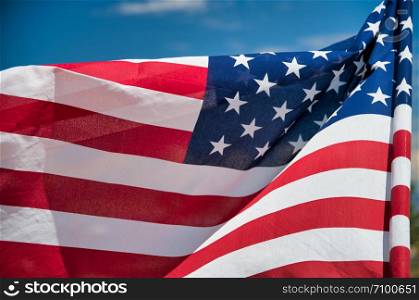 Waving American Flag on blue sky background.