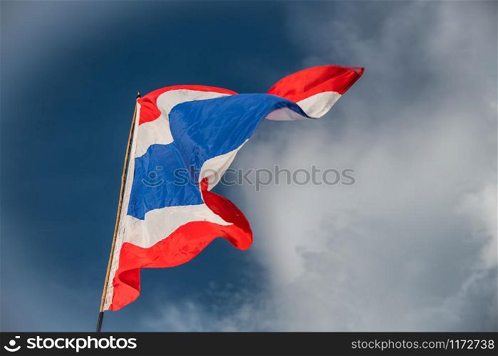Waving flag of Thailand against blue sky.