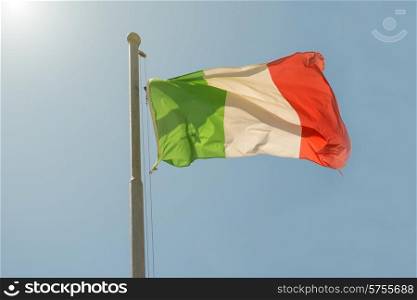 Waving Italian flag on the blue sky background