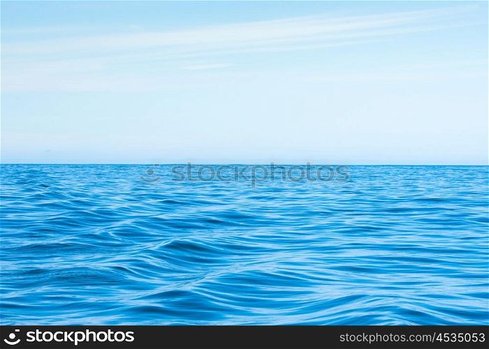 Wavy blue ocean with clouds in the blue sky