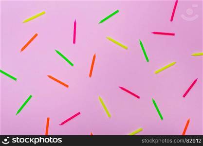 wax colored candles for celebratory cake on a pink background