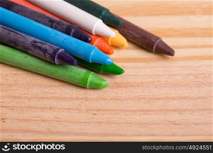 Wax crayons on a wooden background