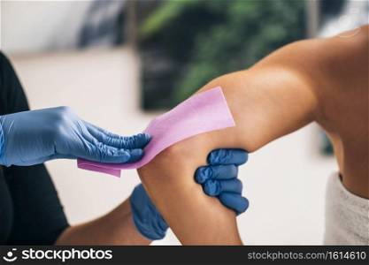 Waxing arms. Beautician removing unwanted hair from female arm with wax strips in a beauty salon.. Waxing Arms 