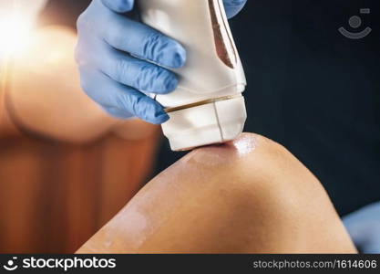 Waxing legs in a beauty salon, wax applicator closeup. Waxing Legs