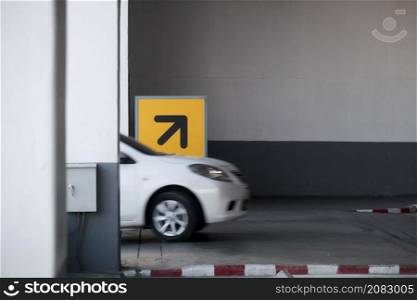 Way up - into the building&rsquo;s parking lot with a sign up right arrow. Arrow sign in yellow and black high above from ground to direct the car in the right direction. Direction up and down for safety.