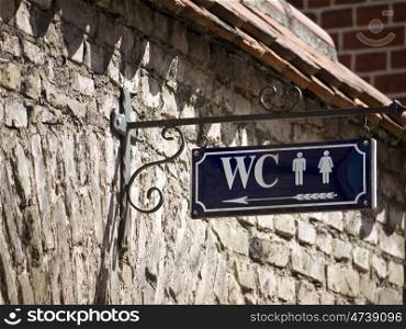 WC-blau. sign for toilets on brick wall
