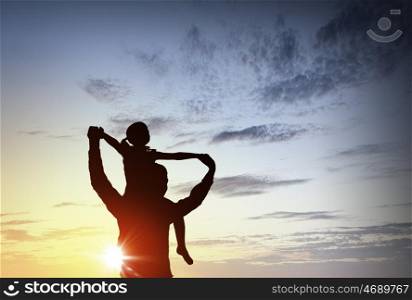 We are happy family. Father and little daughter silhouettes on sunset background