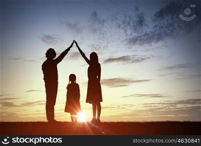 We are happy family. Silhouettes of happy family of three people mother father and child