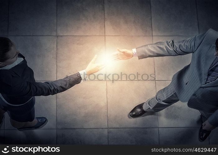We are partners. Top view of two businesswpeople shaking hands