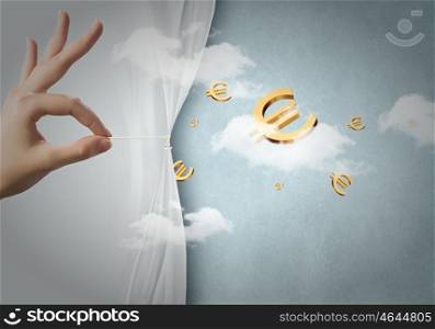Wealth concept. Close up of hand opening white curtain with euro sign behind it