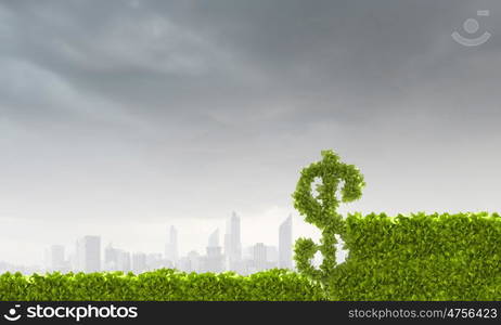 Wealth concept. Conceptual image of green plant shaped like dollar symbol