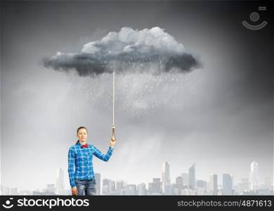 Weather concept. Young woman in casual holding cloud on lead