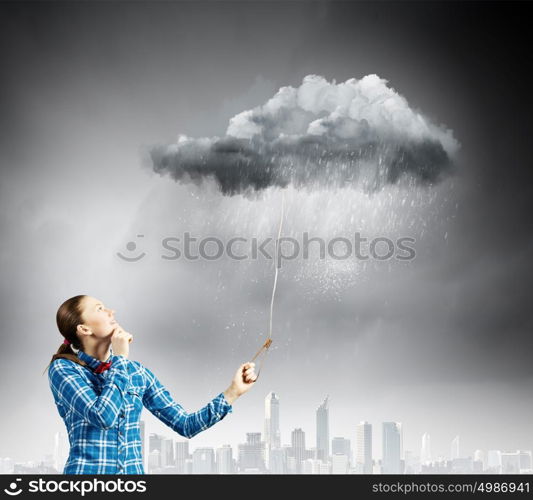 Weather concept. Young woman in casual holding cloud on lead