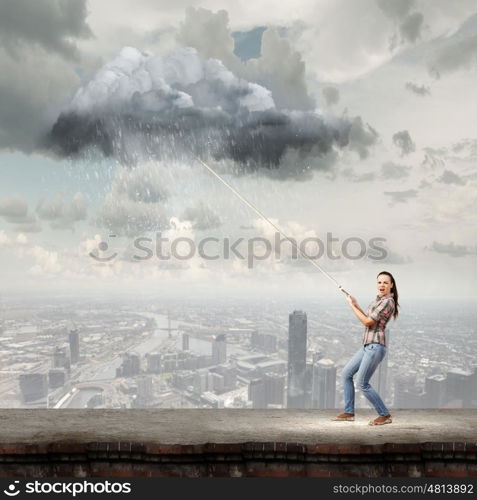 Weather forecast. Young woman in casual catching cloud with rope