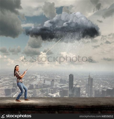 Weather forecast. Young woman in casual catching cloud with rope