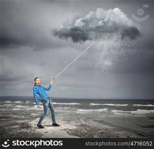 Weather forecasting. Young woman in casual holding raining cloud on lace
