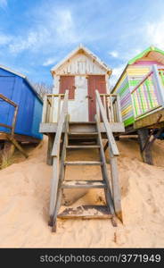 weathered beach hut on golden sand