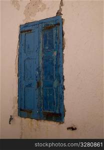 Weathered blue shutters in Mykonos Greece