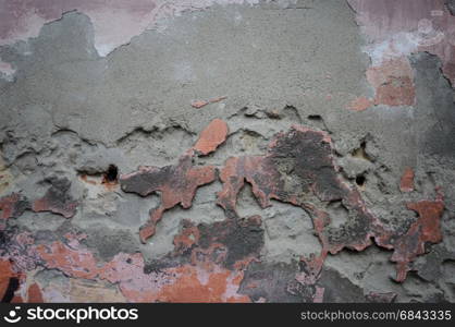 Weathered concrete wall with damaged stucco and old paint