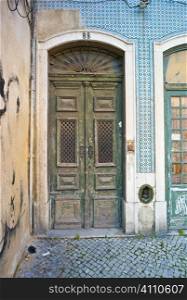 Weathered front door and tiled building exterior, Lisbon, Campo de Ourique