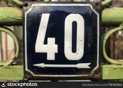 Weathered grunge square metal enameled plate of number of street address with number 40 closeup