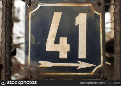 Weathered grunge square metal enamelled plate of number of street address with number 41 closeup