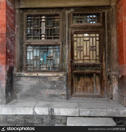 Weathered window with a door of a building at the Imperial Garden, Forbidden City, Beijing, China
