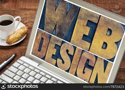 web design word abstract - text in vintage letterpress wood type block on a laptop screen with a cup of coffee