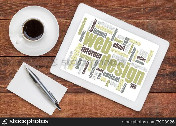 web design word cloud on a digital tablet with a cup of coffee on a rustic wooden table
