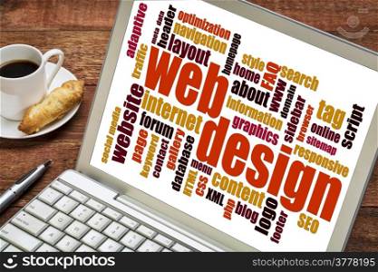 web design word cloud on a laptop screen with a cup of coffee