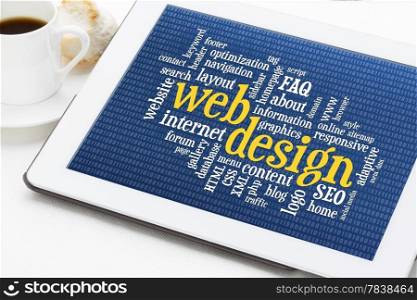 web design word cloud with binary background on a digital tablet with a cup of coffee