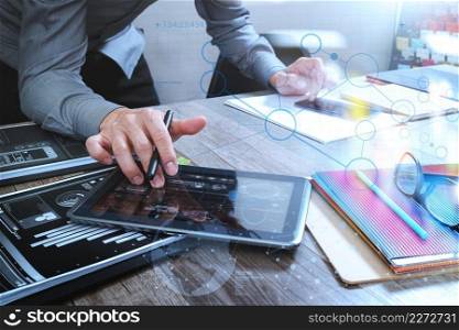 Website designer holding smart phone and working computer digital tablet on wood table,icon graph interface 