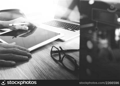 Website designer working blank screen digital tablet and computer laptop with compact server on wooden desk as concept, black white
