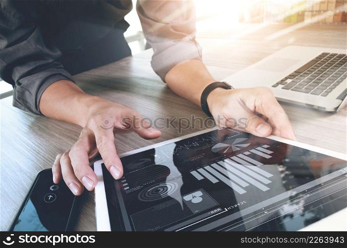 Website designer working digital tablet and computer laptop with smart phone and digital design diagram on wooden desk as concept