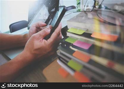 Website designer working digital tablet and computer laptop with smart phone and digital design diagram and stack of books on wooden desk as concep