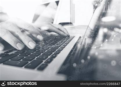 Website designer working digital tablet and computer laptop with smart phone and digital design diagram and stack of books on wooden desk as concept, black white