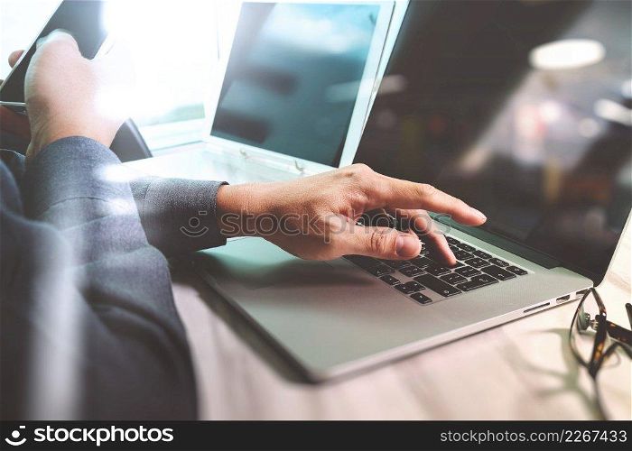 Website designer working digital tablet and computer laptop with smart phone and graphics design diagram on marble desk as concept