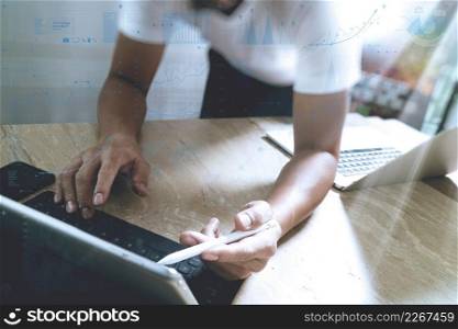 Website designer working digital tablet dock keyboard and computer laptop with smart phone and graphics design diagram on mable desk as concept