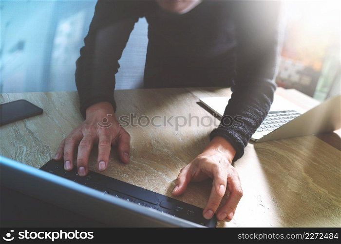 Website designer working digital tablet dock keyboard and computer laptop with smart phone and graphics design diagram on mable desk as concept