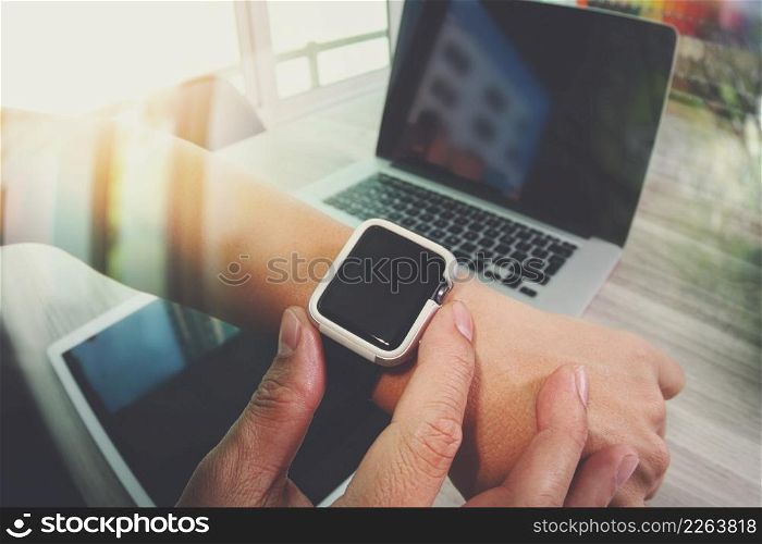Website designer working with smart watch and digital tablet and digital design diagram on wooden desk as concept