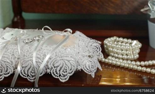 Wedding accessories, rings and pearl necklace. Tracking shot