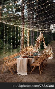 wedding banquet area in a pine forest with an arch on the background for several people