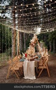 wedding banquet area in a pine forest with an arch on the background for several people